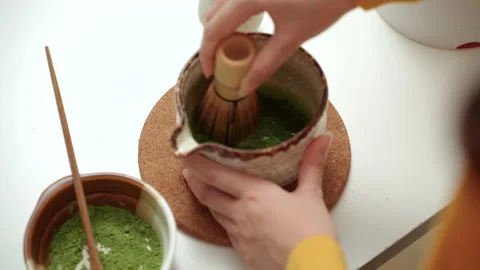 Close up woman's hand making traditional green tea matcha using bamboo natural w Stock Footage 338988218