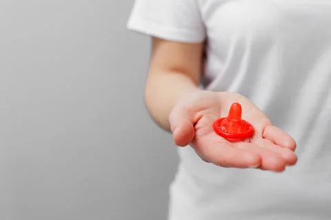 Close up of womans hand with open red condom Stock Photos