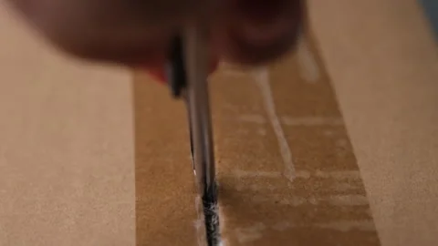 Close-up of woman's hand opening box using cutter. Hands unpacking cardboard box Stock Footage 248503856