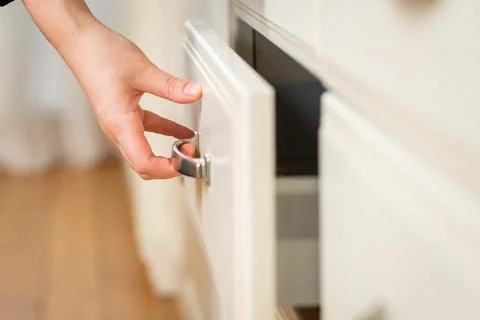 Close-up on woman's hand opens kitchen table drawer Stock Photos