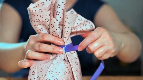 Close-up of a woman's hand packing a gift. 库存影片 105943392