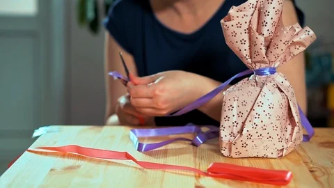 Close-up of a woman's hand packing a gift. Stockbeeldmateriaal 105943510
