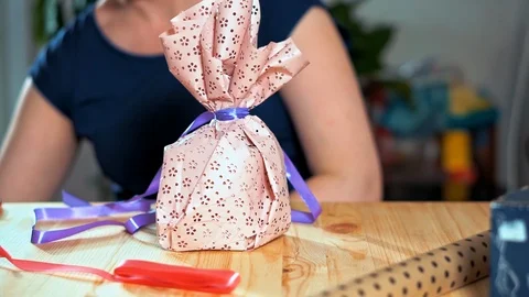 Close-up of a woman's hand packing a gift. Stockbeeldmateriaal 105943685