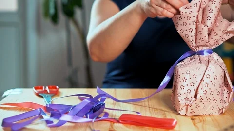 Close-up of a woman's hand packing a gift. 스톡 동영상 105944108