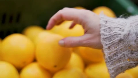 Close-up of a woman's hand picking fruit orange in a supermarket in a shopping c Stock Footage 121081469