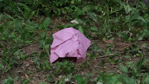 Close-up of a woman's hand picks up a pink piece of paper that was thrown on the Stock Footage 197047262