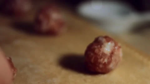 Close-up of woman's hand placing meatballs on dough. Preparing ravioli, a Stock Footage 144828819