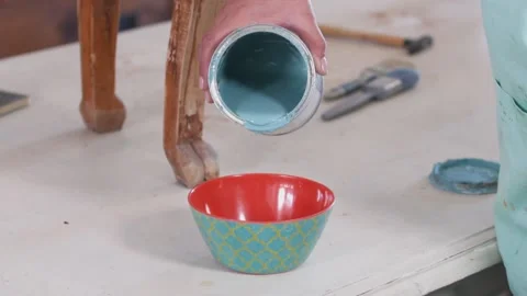 Close-up of woman's hand pouring light blue paint in bowl Stock Footage 130912598