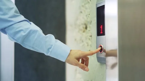 Close up of a woman's hand pressing the elevator call button in a modern office  Stock Footage 240927736