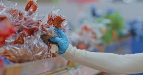 Close-up, a woman's hand in a protective glove takes bread from the supermarket Stock Footage 151286597