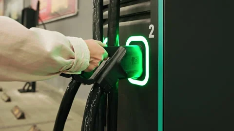 Close-up woman's hand pulls out power cable closes lid electric vehicle EV charg Stock-Footage 292551503
