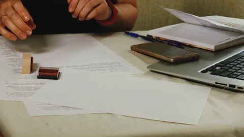 Close-up of a woman's hand that puts a stamp on a piece of paper Stock Footage 108055732