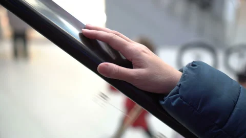 Close-up of a woman's hand on the railing of a moving escalator. Video stock 124788503