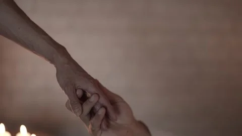 Close-up of a woman's hand reaching for a table with candles, intimate atmospher Stock Footage 314651353