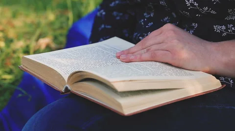 Close up woman's hand reading a book in the park. Video stock 62256844