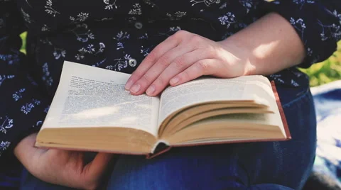 Close up woman's hand reading a book in the park. Vidéo 62256860