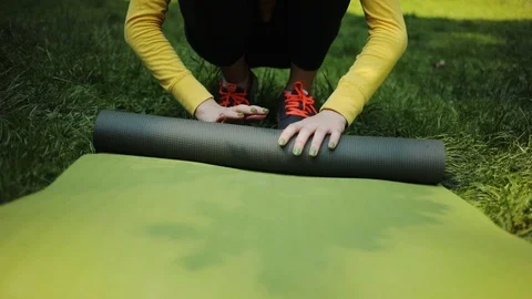 Close-up of a woman's hand is rolling a carriage after yoga exercises outdoor in Video stock 92303682