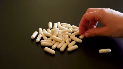 Close up of a woman's hand selecting multiple white pills. Stock Footage 157818250