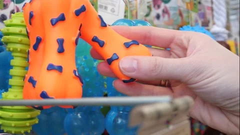 Close up of woman's hand selecting rubber bone dog toys Stock Footage 304900910