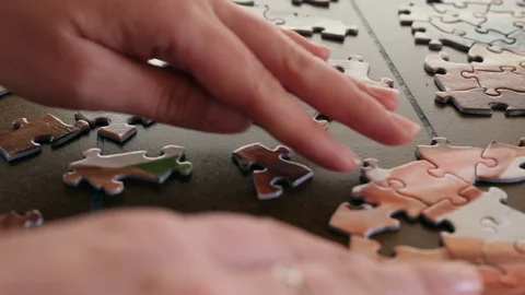 Close-up Of Woman's Hand Solving A Jigsaw Puzzle Stock-Footage 129498997