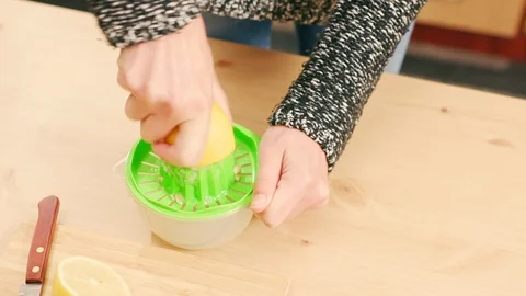 Close up of a woman's hand squeezing lemon on wooden table Video stock 121295783