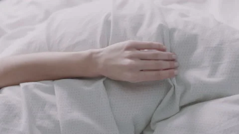 Close up of woman's hand stroking the bed sheets Stock Footage 131064344