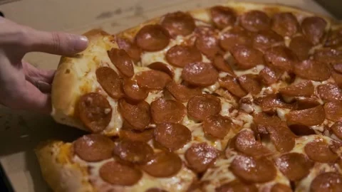 Close-up of a woman's hand taking a slice of pizza with salami 스톡 동영상 135422908