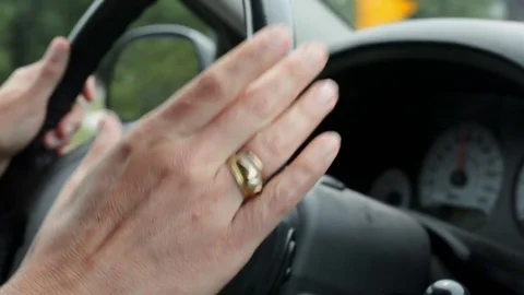 Close-up of a woman's hand tapping rhythm on a car wheel while driving Video stock 76317889