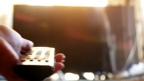 Close up of woman's hand with a television remote control changing channels at Stock Footage 71794751