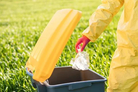Close up woman's hand throwing away plastic bottle in nature. Environmental d Stock Photos