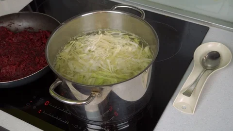 Close-up of woman's hand throwing cabbage into the pan. Video stock 99044636