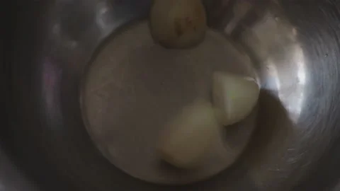 Close-up, Woman's Hand Throws Several Heads of Peeled Garlic into Metal Bowl Stock Footage 157651267