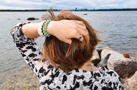 Close-up of a woman's hand touching her short brown hair against Foto stock