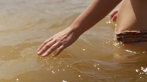Close-up of a woman's hand touching the water of a lake, standing in the lake Stock Footage 116790207