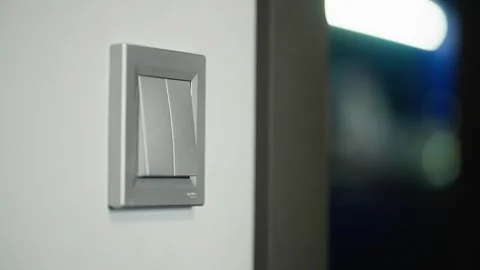 Close-up of a womans hand turning on the light with a switch. Video stock 310541891
