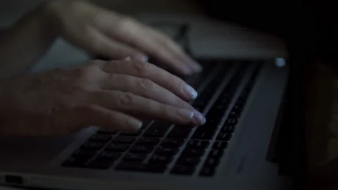 Close-up of a woman's hand typing and working with a laptop at night Stock Footage 88763566