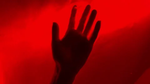 Close-up of womans hand under red water performs chaotic smooth movements water Stock Footage 312451431