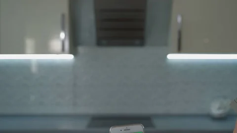 Close up woman's hand use smartphone with vertical green screen on kitchen at Stock Footage 129055384