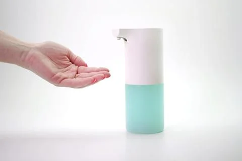 Close-up of a woman's hand using an automatic dispenser. Concept of infection Stock Photos