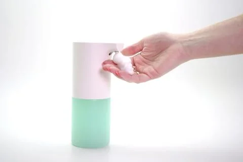 Close-up of a woman's hand using an automatic dispenser. Concept of infection Foto stock