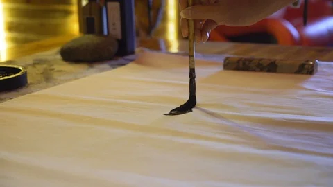 Close-up of a woman's hand using a large ink brush to write traditional Video stock 110831742