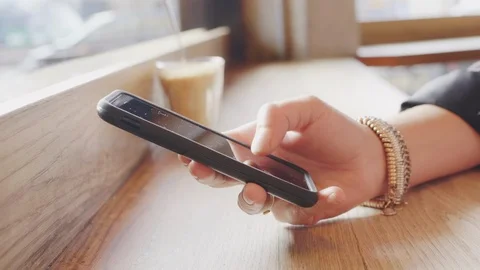 Close up of woman's hand using smart phone in coffee shop. Stock Footage 86068646