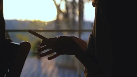 Close-up of woman's hand using smartphone on sunset background Stock Footage 200820509