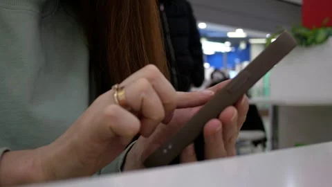 Close-up of a woman's hand using a smartphone at public place or fast food cafe. Stock Footage 311977788
