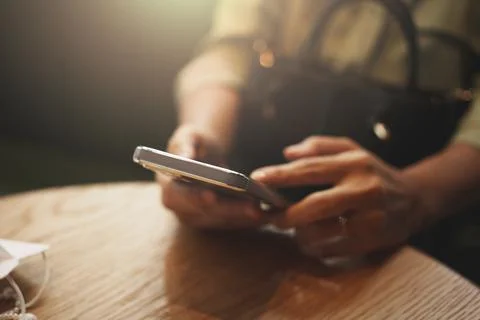 Close-up of woman's hand using a smartphone during coffee break. Stock-Fotos