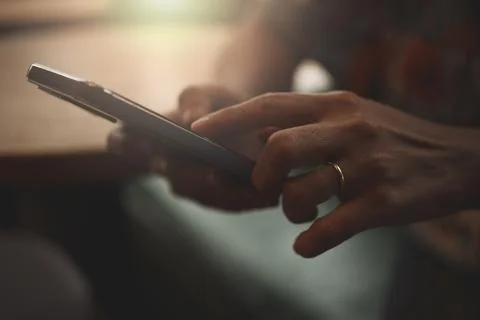 Close-up of woman's hand using a smartphone during coffee break. Stock Photos
