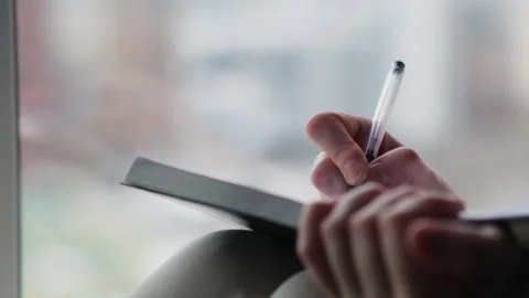 Close-up of woman's hand writing in a journal her goals and dreams. Video stock 271221793