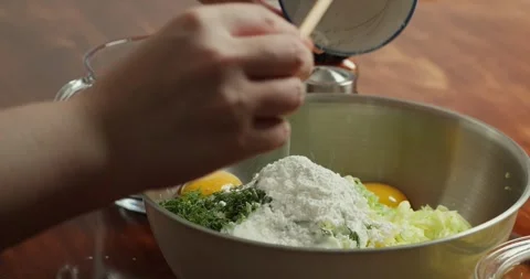 Close up of a womans hands adding flour to all the other ingredients to make Stock Footage 317075032