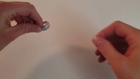 Close-Up Woman's Hands Admiring Silver Ring With Pink Diamond and Placing on Stock Footage 85000174
