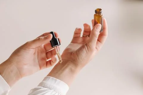 Close-up of a Woman's hands applying essential oil on her wrist indoors Stock Photos